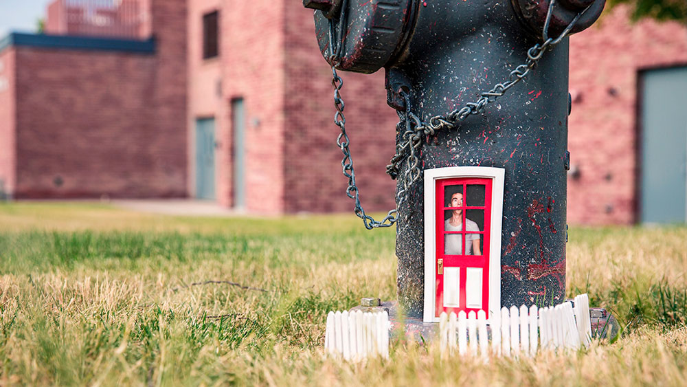 Tiny front door and picket fence on a fire hydrant. Having a front door that is outdated or need of repair can define your home.