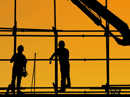 Silhouette of two construction workers on scaffolding, signifying the current condition of the architectural and construction industries.