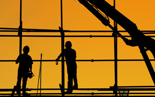 Silhouette of two construction workers on scaffolding, signifying the current condition of the architectural and construction industries.