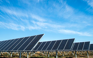 Lincoln Electric Solar Farm An array of solar panels at a Lincoln Electric facility in Lincoln, Nebraska under a blue sky with wispy white clouds