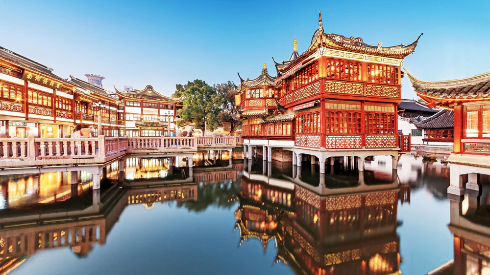 Yuyuan Garden in Shanghai displaying Intricately carved wood and sweeping rooflines over a waterway