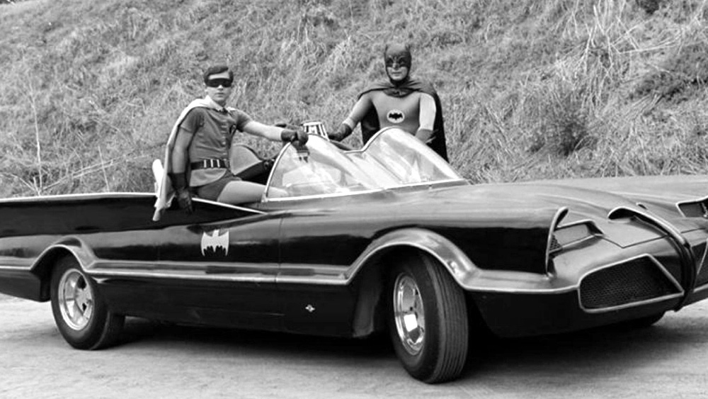 1960's Batman and Robin standing by the Batmobile in front of Bronson Caves where they filmed scenes in front of the Batcave