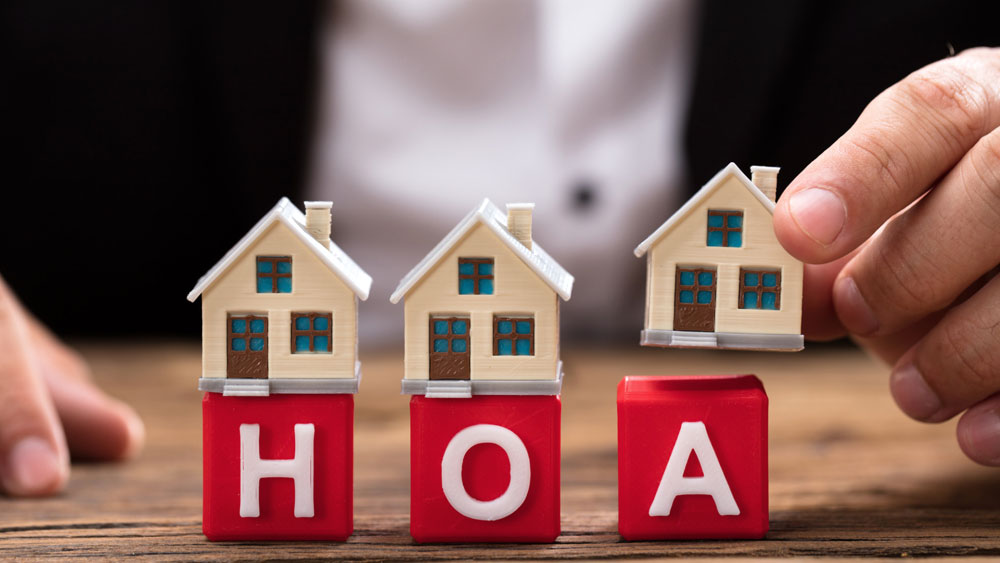 Tiny houses set atop red toy blocks with the letters HOA