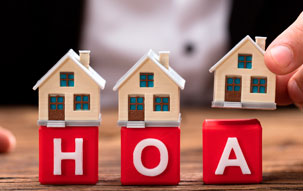 Tiny houses set atop red toy blocks with the letters HOA