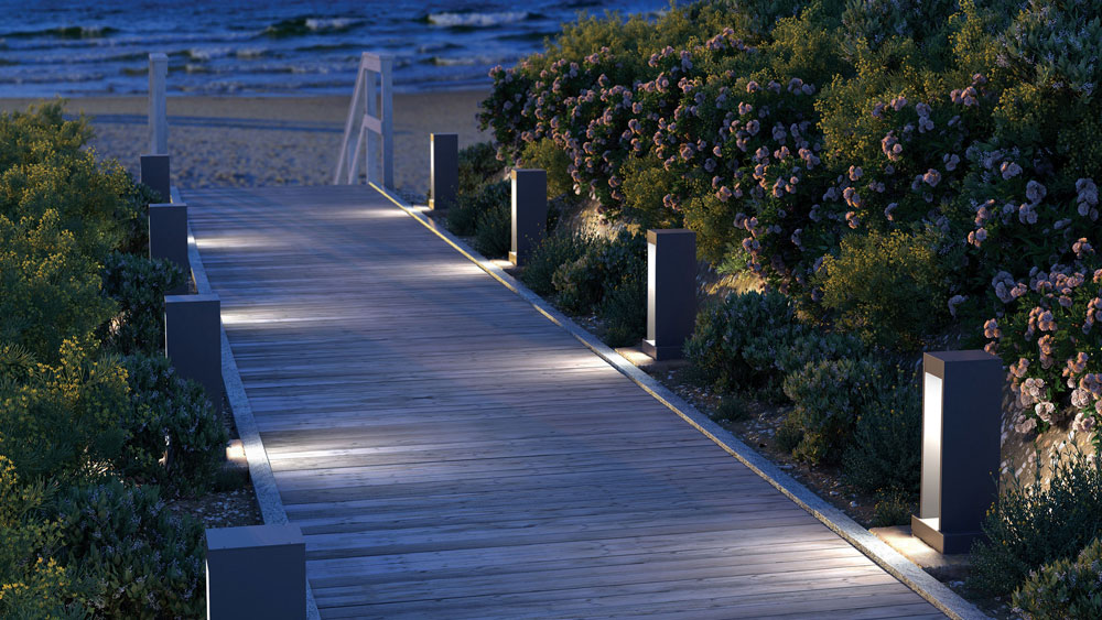 Night photo of residential exterior with Syntra tall modern bollard lights in grey powder coat finish from Tech Lighting