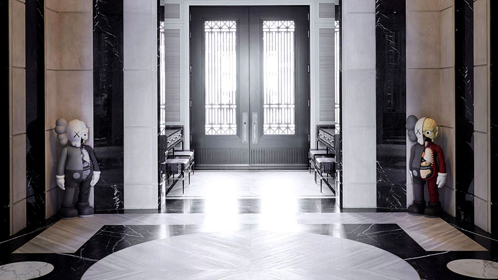 Sunlight floods through an iron double door in Drake's foyer into the custom designed Nero Marquina and Escarpment White marble inlaid floor.