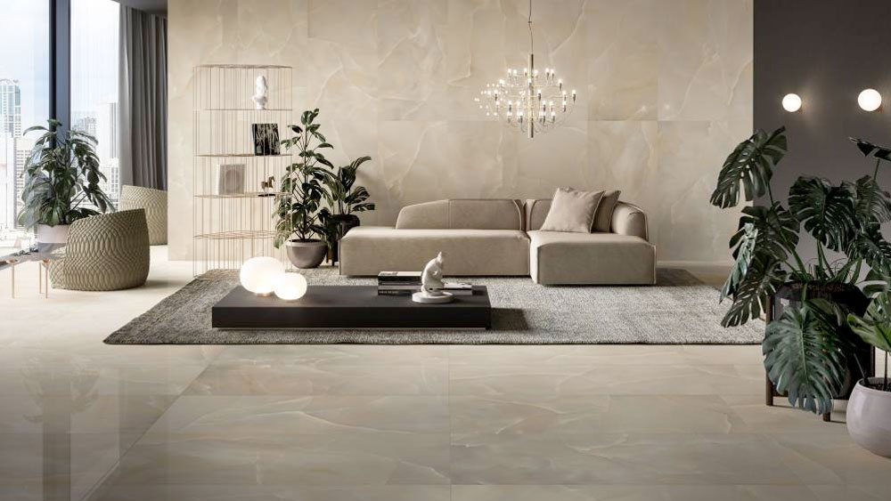 A sun-filled living room floor and walls tiled in a polished onyx porcelain from Refin's Prestigio Onyx line.